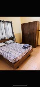 a bed with a wooden frame in a room at Maison meublée à Calavi à 2mn du supermarché EREVAN in Abomey-Calavi