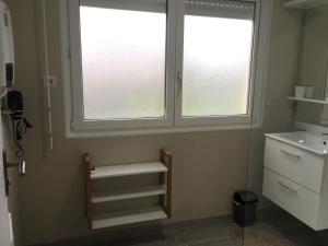 łazienka z 2 oknami, umywalką i schodami w obiekcie Le petit coin de la Haute Somme w mieście Hem-Monacu