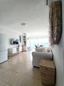 Apartamento, La Cala Vicent&Alba في كالا دي فينيسترات: غرفة معيشة بها أريكة وتلفزيون