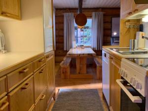 a kitchen with a table in the middle of it at Ruska 2, Ylläs - Hirsimökki järvi- ja tunturimaisemilla in Äkäslompolo