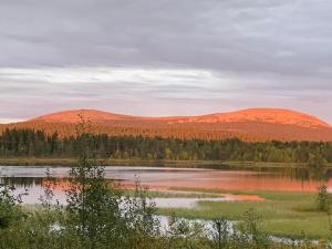 a view of a lake with hills in the background at Ruska 2, Ylläs - Hirsimökki järvi- ja tunturimaisemilla in Äkäslompolo