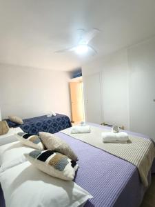um quarto com três camas com almofadas em Apartamento, La Cala Vicent&Alba em Cala de Finestrat