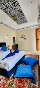 - une chambre avec 2 lits dotés d'oreillers bleus sur un tapis dans l'établissement Riad Amazing, à Marrakech