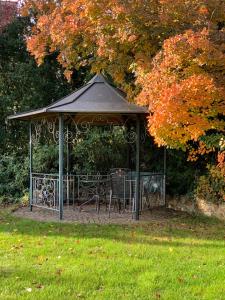 a gazebo with a table and chairs in a park at Haus am Pfingstborn in Ober-Mörlen