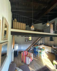 a living room with a loft with a table and a staircase at El Mirador de las Cuencas in Abiada
