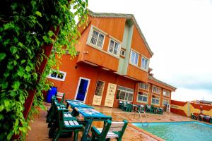 a building with a table and chairs next to a pool at Benin Metropole Hotel in Parakou