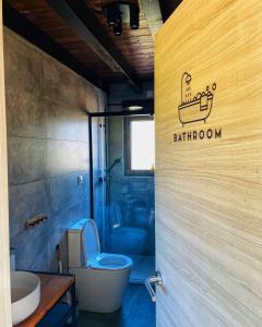 a bathroom with a toilet and a bathroom sign on the door at El Mirador de las Cuencas in Abiada