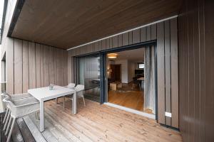 Habitación con mesa, sillas y suelo de madera. en Lakeside Luxury Apartments en Zell am See