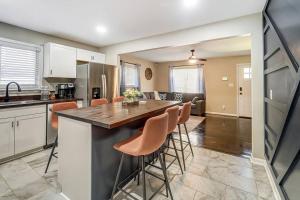 a kitchen with a large island in a kitchen with orange bar stools at Chatlotte Charm Haven with Outdoor TV in Charlotte