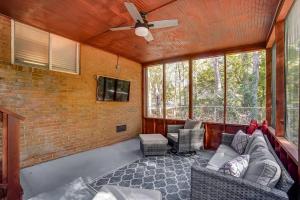 a living room with a couch and a ceiling fan at Chatlotte Charm Haven with Outdoor TV in Charlotte