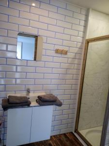 La salle de bains blanche est pourvue d'un lavabo et d'une douche. dans l'établissement Chambre studio, à Calais