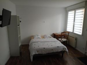 - une chambre avec un lit, une table et une fenêtre dans l'établissement Chambre studio, à Calais