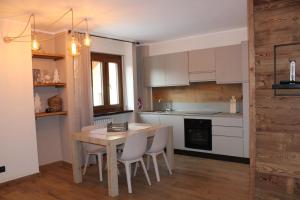 a kitchen with a table and chairs in a room at 4Seasons house Faure in Sauze dʼOulx