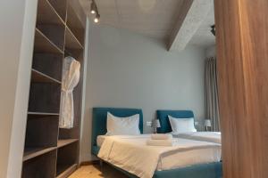 a bedroom with a bed with blue chairs and shelves at Gastello hotel in Bishkek