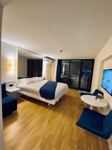 orbi city sea view في باتومي: غرفة فندقية بسرير وطاولة وكراسي