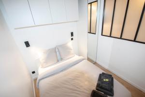 niewielka sypialnia z łóżkiem i oknem w obiekcie Appartement cosy Montorgueil (Bonne Nouvelle) w Paryżu