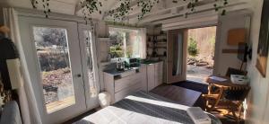 eine Küche mit einem Waschbecken und zwei großen Fenstern in der Unterkunft La Rikiki du petit ruisseau in Mandeville