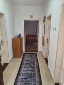 - un couloir avec une chambre dotée d'un canapé et d'un tapis dans l'établissement Apartman Vuković, à Foča
