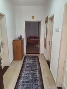 een hal met een kamer met een bank en een tapijt bij Apartman Vuković in Foča