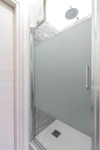 a shower with a glass door in a bathroom at Metro Sesto M1 Martini Relax Loft Wi-Fi & Netflix in Sesto San Giovanni