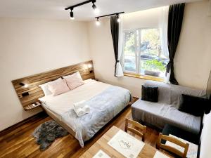 魯塞的住宿－Malavi TN2 top center apartment Ruse，一间卧室配有一张床、一张沙发和一张桌子
