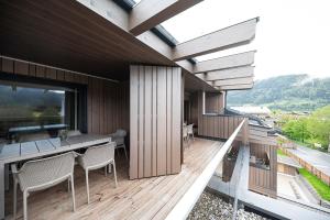 a balcony of a house with a table and chairs at Lakeside Luxury Apartments in Zell am See