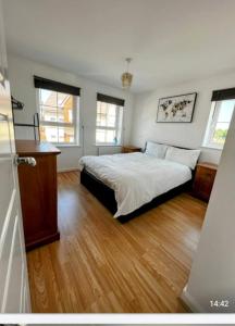 a bedroom with a bed and a wooden floor at Beautiful 4 Bedroom Treasure home in Hemel Hempstead