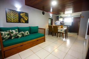 a living room with a green couch and a table at Winterville Gravatá Flat 425 - Próximo das piscinas in Gravatá