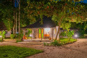 een kleine hut met een rieten dak onder een boom bij The Tropical Beach Resort in Ko Chang