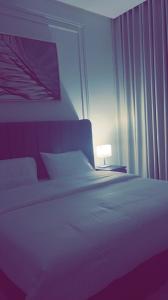 a bedroom with a white bed and a lamp at شالية بيرليز الفندقي in Al Khobar