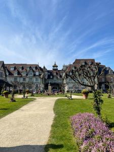 uma casa grande com um caminho num parque em le Pullman em Deauville