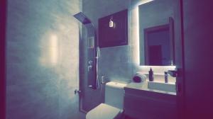 a bathroom with a toilet and a sink and a mirror at شالية بيرليز الفندقي in Al Khobar