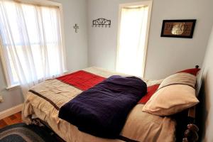 a bed in a bedroom with a cross on the wall at Lane's End near Deep Creek Lake in Swanton
