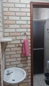 a bathroom with a white sink and a pink towel at Sobrado praia cachoeira in Florianópolis
