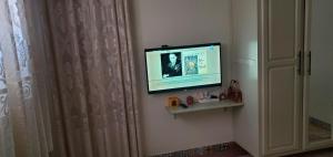 - une télévision à écran plat sur un mur à côté d'un rideau dans l'établissement Dar sirin, à Essaouira