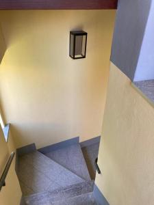 un escalier dans un bâtiment avec une lumière sur le mur dans l'établissement Casa Teresa, à Germignaga