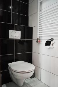 La salle de bains est pourvue de toilettes blanches et de carrelage noir. dans l'établissement Downtown studios Budapest, à Budapest