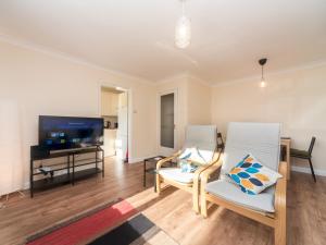 a living room with two chairs and a flat screen tv at Pass the Keys Great apt 20 mins central London in Surbiton