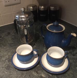 Duas chávenas azuis e brancas e um bule de chá no balcão. em Close to Jurassic Coast 3 Bed modern house em Wool