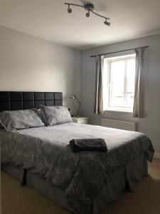 a bedroom with a large bed with a robe on it at Close to Jurassic Coast 3 Bed modern house in Wool