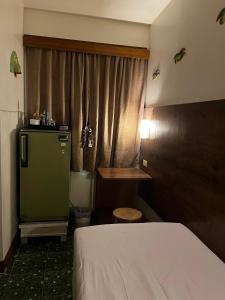 a bedroom with a bed and a green refrigerator at Baan Rachaya in Chiang Mai