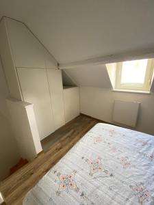 Zimmer im Dachgeschoss mit einem Bett und einem Fenster in der Unterkunft Cosy maison de ville Rouennaise in Rouen
