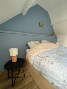 1 dormitorio con 1 cama con pared azul en Cosy maison de ville Rouennaise, en Rouen
