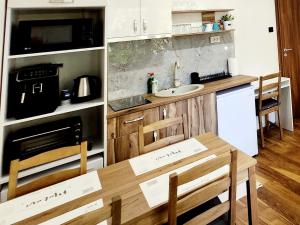 魯塞的住宿－Malavi TN2 top center apartment Ruse，厨房配有带2把椅子的桌子和水槽