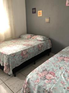 瓜魯雅的住宿－Kitnet do Costa Praia do Pereque Guaruja!!!，一间客房内配有两张床的房间