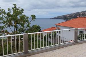 a white fence with a view of the water at Sol e Mar by the airport in Santa Cruz