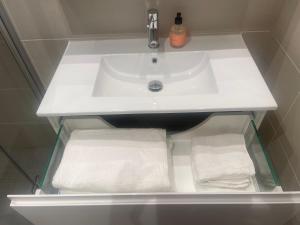 a sink in a bathroom with towels underneath it at Seventh Apartment Lillestrøm in Lillestrøm