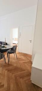 Habitación blanca con mesa, sillas y escritorio. en Apartment Tivoli en Liubliana