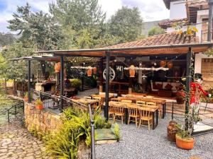 a restaurant with wooden tables and chairs in a building at Hotel Casa Cantabria Campestre in Villa de Leyva