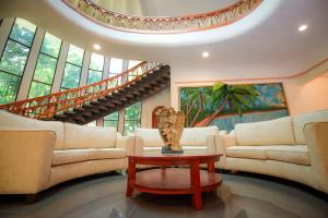 a living room with couches and a table and a staircase at Wisdom Boutique Resort in Kandy